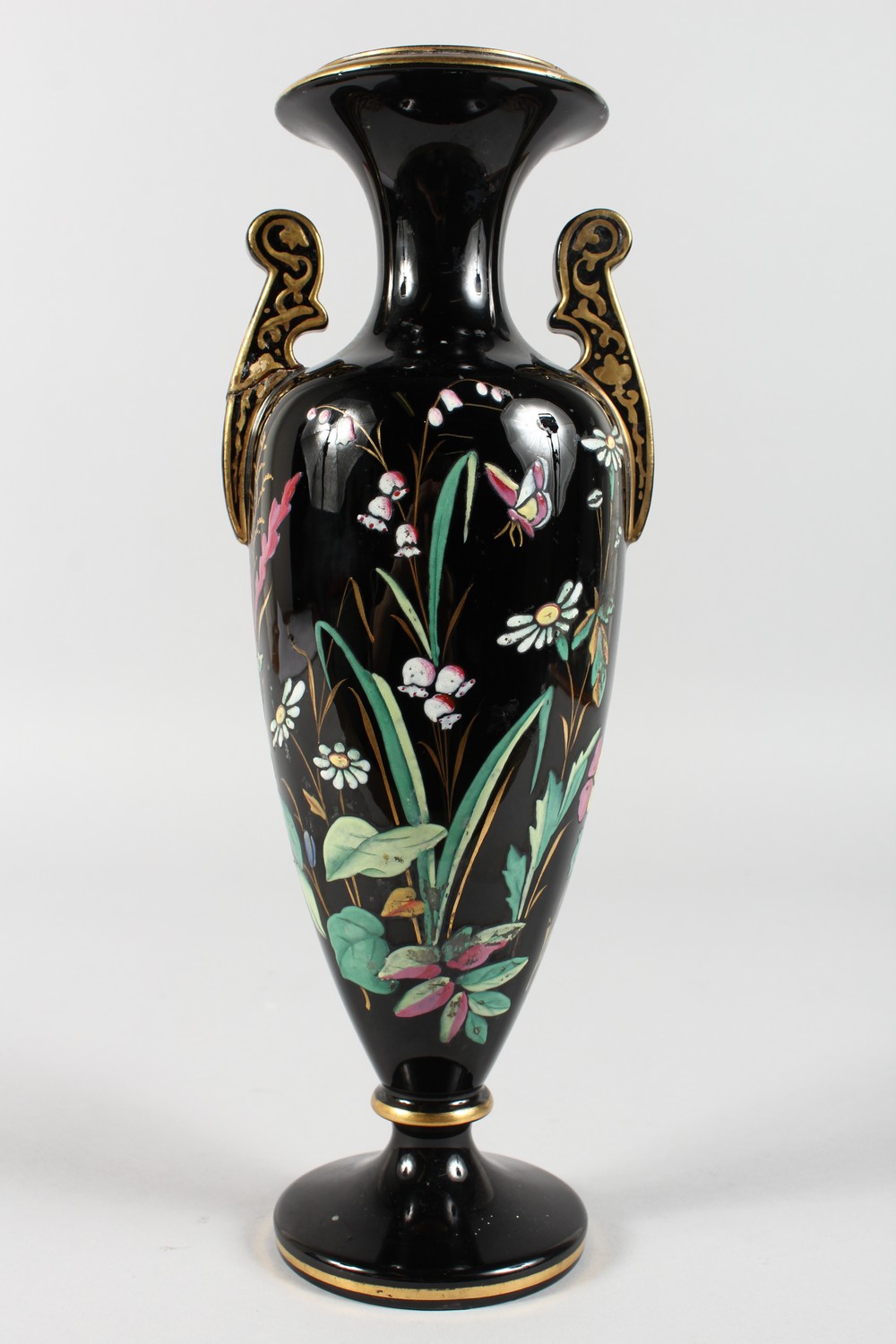 A VICTORIAN BLACK GLASS TWO-HANDLED VASE, painted with flowers and