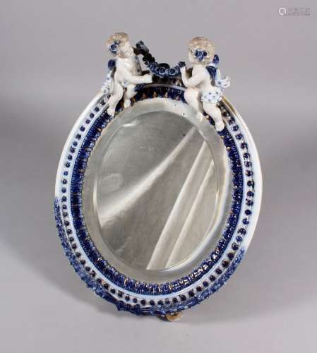 A DRESDEN PORCELAIN OVAL MIRROR, with two cupids and garlands. 14ins high.