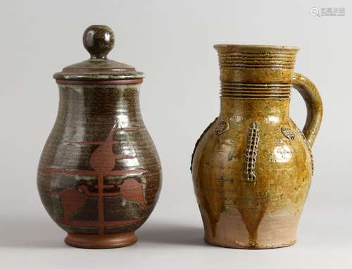 A 19TH CENTURY TERRACOTTA JUG, part glazed, with applied moulded decoration, and a pottery jar and