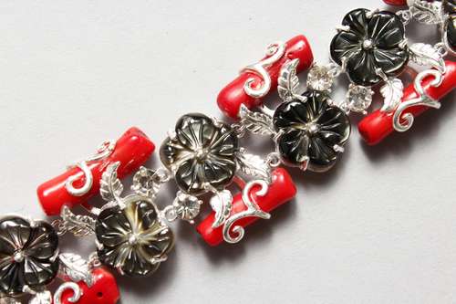 A SILVER, CORAL AND MOTHER-OF-PEARL FLOWER HEAD DESIGN BRACELET. 7.5ins long.