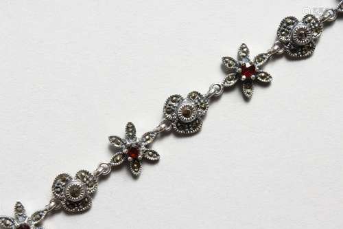 A SILVER, GARNET AND MARCASITE FLOWER HEAD BRACELET. 7ins long.