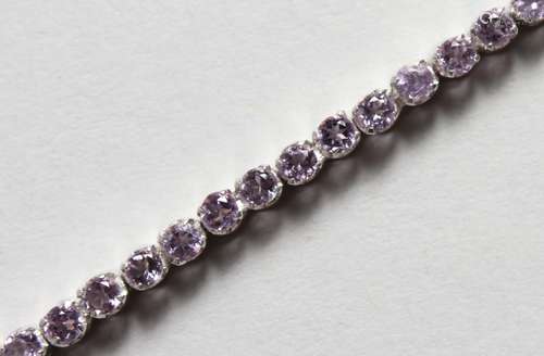 A SILVER AND AMETHYST LINE BRACELET. 7ins long.