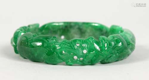 A CHINESE CARVED APPLE GREEN JADE BANGLE. 3ins diameter.