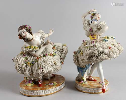 A PAIR OF CONTINENTAL PORCELAIN FIGURES OF DANCERS, wearing floral encrusted dresses. 7ins and 9.