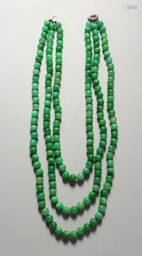 A GOOD JADE THREE-ROW NECKLACE, with diamond and ruby set clasp.