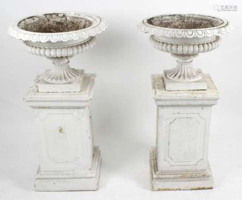 A pair of painted cast iron garden urns,