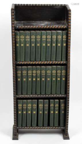 A small oak freestanding bookcase containing twenty nine Charles Dickens bound volumes,