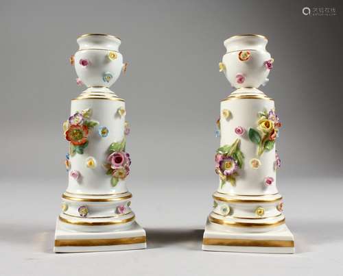 A SMALL PAIR OF MEISSEN PORCELAIN FLOWER ENCRUSTED CANDLESTICKS, on square bases. Cross swords