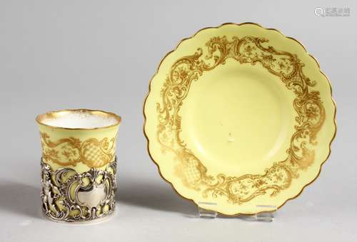 A ROYAL WORCESTER COFFEE CAN AND SAUCER, with pierced silver holder, yellow ground with gilt