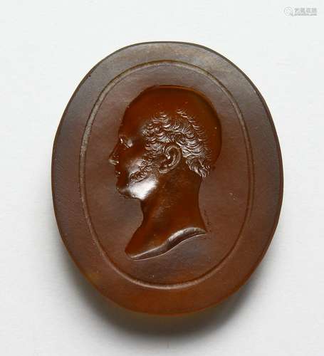 AN INTAGLIO CARVED AMBER GLASS BUST OF A MAN, in the Roman style. 2ins high.