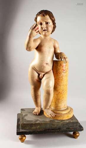 A VERY GOOD 18TH CENTURY PAINTED GESSO AND CARVED WOOD MODEL OF A CHERUB, standing next to a faux