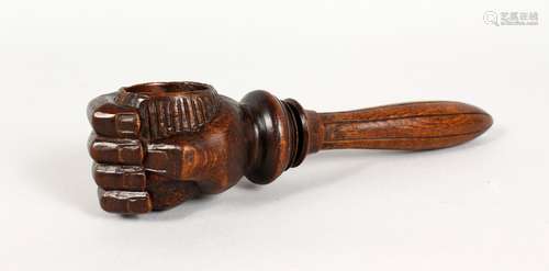 A CARVED WOOD NUTCRACKER, modelled as a clenched fist. 8.5ins long.