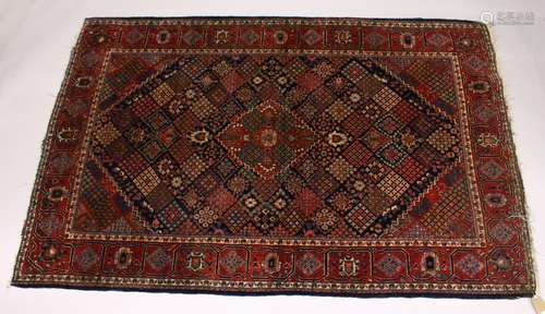 A KASHAN RUG, 20th Century dark blue ground with allover stylized emblems. 6ft 8ins x 4ft 3ins.