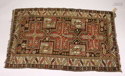 A PERSIAN CAUCASIAN RUG, EARLY 20TH CENTURY, with three large cross shaped medallions, within a