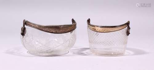 TWO CONTINENTAL CUT GLASS CIRCULAR BASKETS, with silver swing handles.