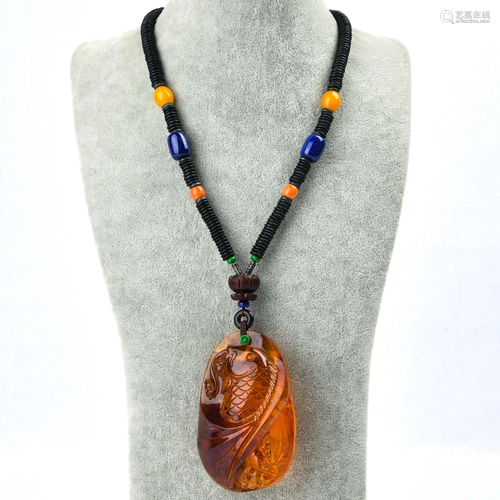 A CARVED AMBER PENDANT