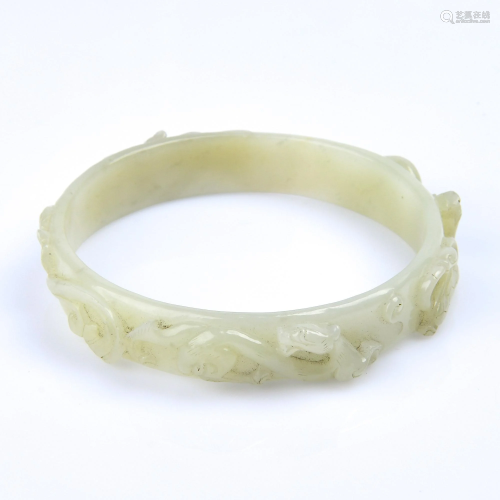 A CARVED WHITE JADE BANGLE