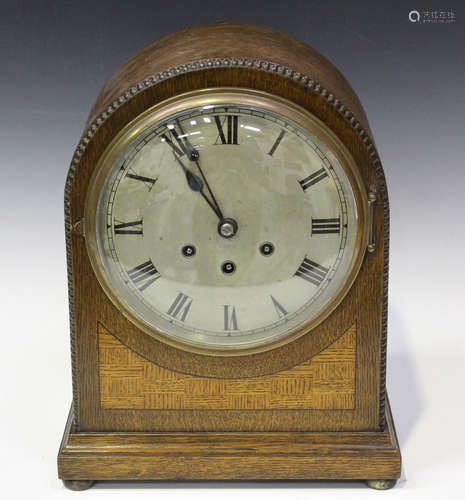 A George V oak mantel clock with eight day movement chiming on gongs, the backplate with Gustav