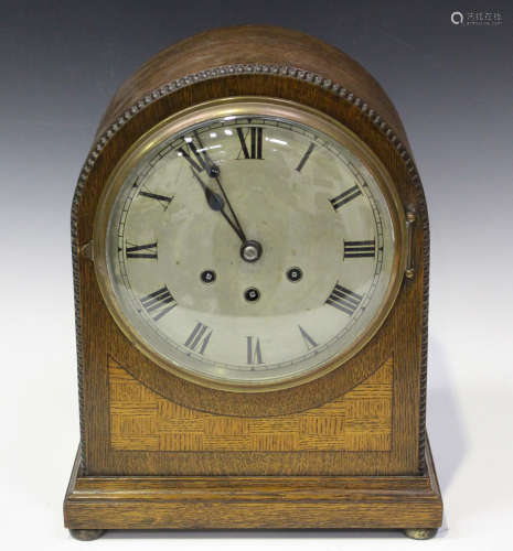 A George V oak mantel clock with eight day movement chiming on gongs, the backplate with Gustav