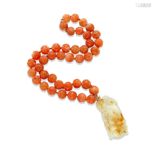 A carved carnilian necklace with a white jade pendant