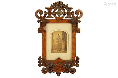 A Victorian hand tinted photograph housed in a oak Gothic Revival frame