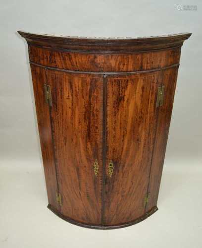 A 19TH CENTURY MAHOGANY BOW FRONT CORNER CUPBOARD, with well fitted interior, 109cm high