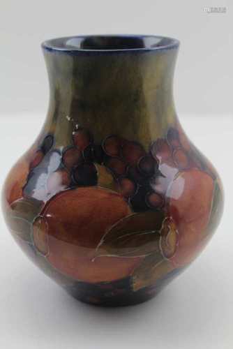 AN EARLY 20TH CENTURY MOORCROFT POTTERY VASE, tube lined and painted pomegranate design, impressed