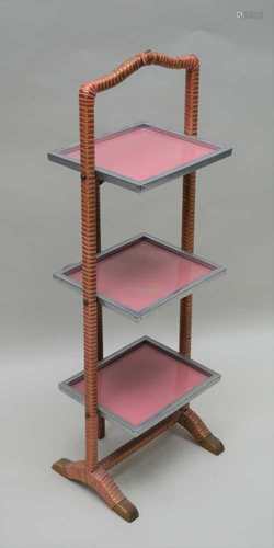 AN ART DECO FOLDING THREE-TIER CAKESTAND, having chrome framed shelves and gold & pink bound