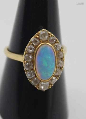 A MARQUISE SHAPED OPAL & DIAMOND RING, the central fiery opal surrounded by fourteen bright cut