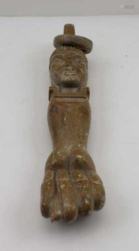 A TRIBAL CARVED STONE FETISH ITEM having clenched fist terminal with mask and loose ring fitting,