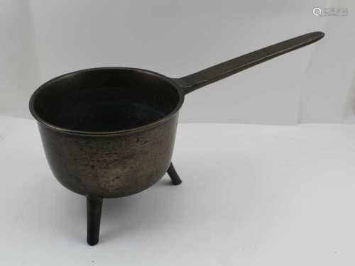 AN 18TH CENTURY CAST BRONZE SKILLET PAN, raised upon three integral feet, the long handle