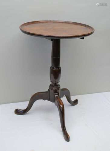 A GEORGIAN MAHOGANY SAUCER TILT TOPPED TABLE on turned column and three downswept legs, 71cm high