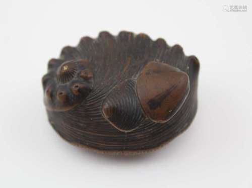 A JAPANESE MEIJI PERIOD CARVED WOOD NETSUKE, in the form of a nautilus shell, with two clam shells