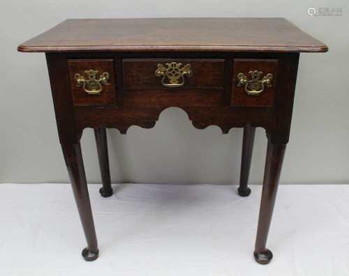 A GEORGIAN OAK LOWBOY, with plain top, over three drawers, with carved apron, supported on four