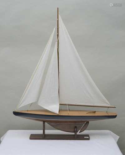 A SCRATCH BUILT MODEL POND YACHT single-masted, with three cotton sails, mounted on a plinth base,