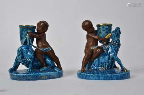 A pair of Worcester turquoise figural candlesticks, with bisque cherubs and glazed baskets supported