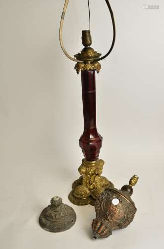 A 19th Century gilt brass lamp base, with cranberry glass central column, raised on a scrolling