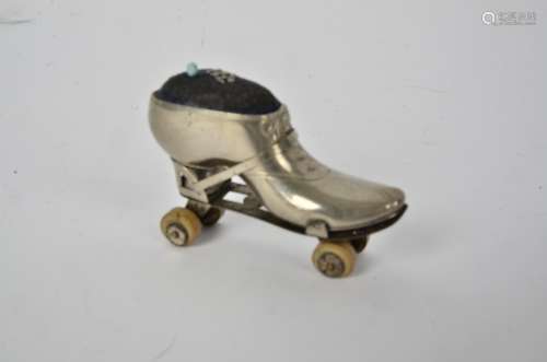 An Edwardian novelty pin cushion in the form of a roller skate, with early rubberised wheels, length
