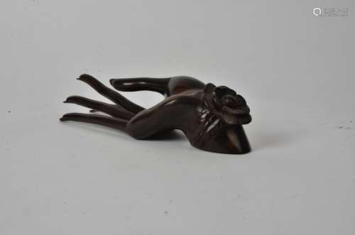 An Indonesian hardwood figure of a hand, with long fingernails and floral accessory, marked to the