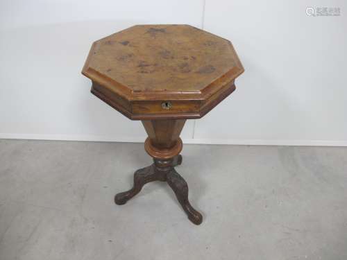 A Victorian octagonal walnut sewing table, with moulded rising top, raised on a carved tripod