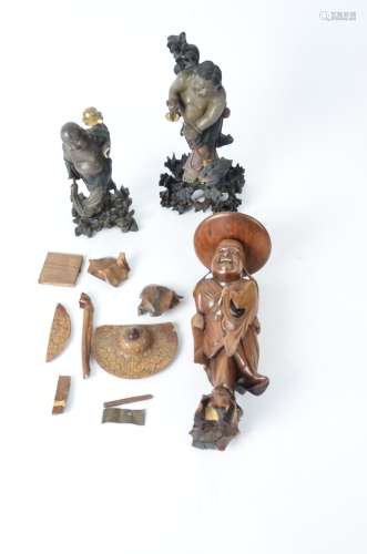 Two Asian polychrome figures, one dangling a tsuba into the mouth of a mythical creature, height