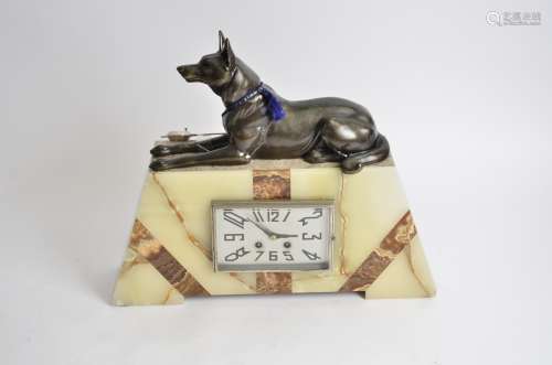 A large Art Deco marble and onyx mantel clock, surmounted with an Alsatian, 38cm high x 45cm wide