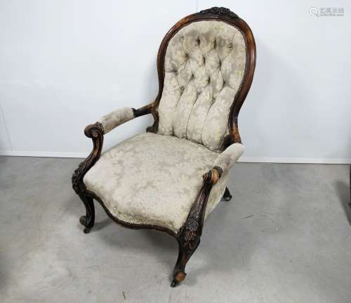 A Victorian walnut framed spoon back open arm chair, the shaped show wood frame carved with leaf