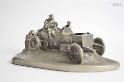 A heavy sculptural cast desk object taking the form of early motor car, with space for an inkwell,