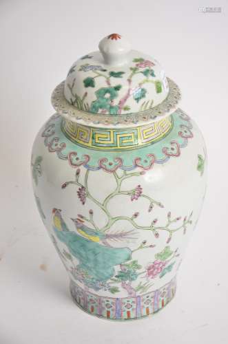 A Chinese covered jar with Famille rose decoration, with lotus panels, rising to a study of birds