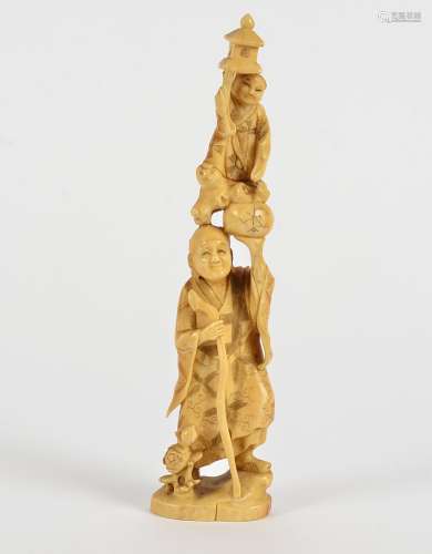 A Meiji period Japanese ivory Elder and child figure, the Elder supporting a child on one raised