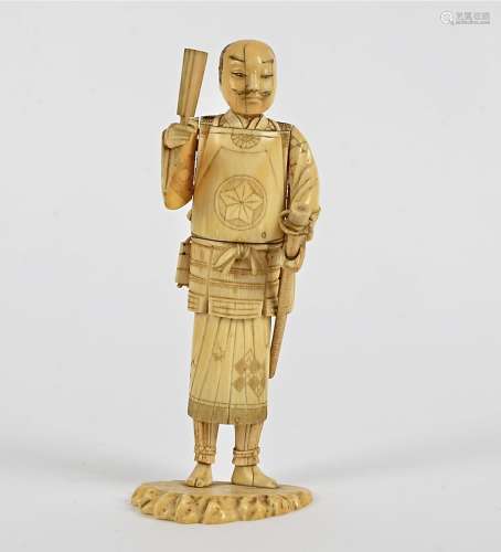 A Meiji period Japanese okimono of a Samurai , holding an implement and sword, the base with