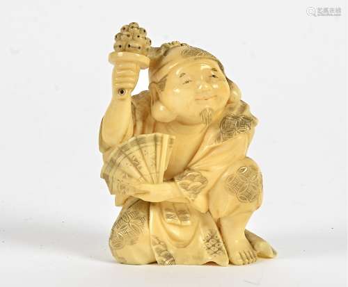 A seated Japanese Meiji period gentleman, holding a fan, artist's marks to base, height 8cm