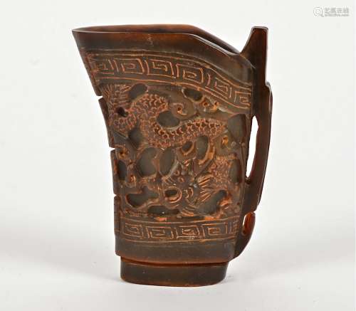 A Chinese horn libation cup with dragon to each side and key fret border, probably mid 20th