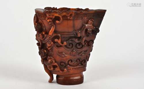 An early 20th Century Chinese carved horn libation cup, the design with multiple raised crawling